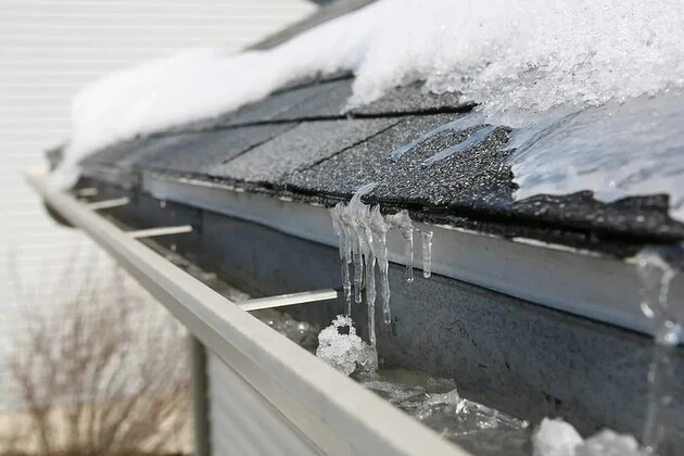 Commercial roof with snow and ice buildup requiring repair services