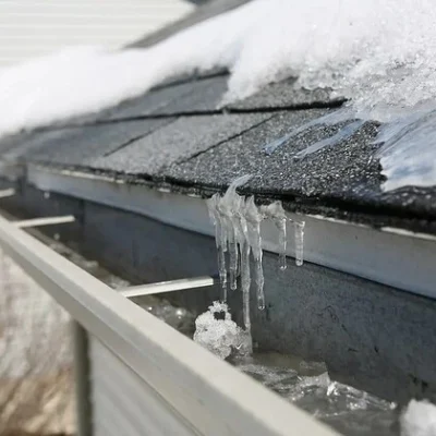 Commercial roof with snow and ice buildup requiring repair services